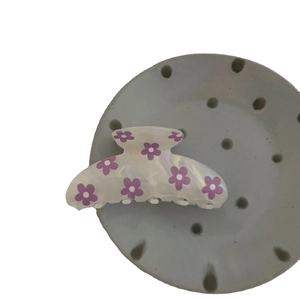 Minimalist cream-colored acetate hair claw clip with purple floral print and sturdy teeth