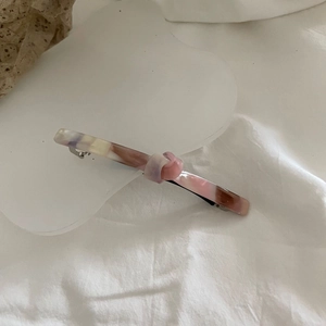 Elegant knotted acetate hair clip with pink marble pattern on a clean white background