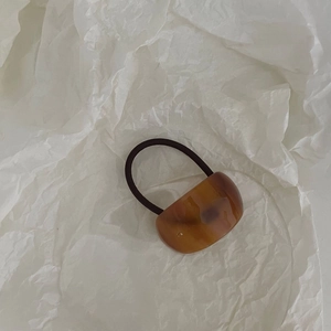 Détail d'élastique à cheveux en acétate écaille de tortue avec bande noire élastique