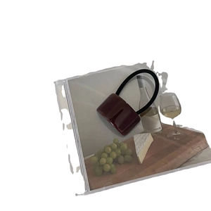 Sac seau rouge foncé minimaliste avec poignée noire courbée dans un décor artistique