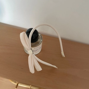 Eleganter beiger Stoff-Haarreif mit seitlicher Schleife für einen schicken Look