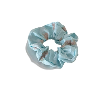 Light blue floral scrunchie with pink embroidery on satin texture for hair styling