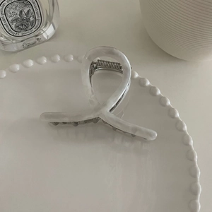 Pince à cheveux en acétate blanc marbre style français sur un plateau décoratif
