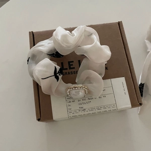 Floral scrunchie with rose pattern and pearl rhinestone charm on a gift box