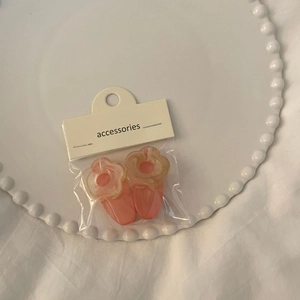 Cute Korean floral resin hair clips in pink and clear jelly colors on a white plate