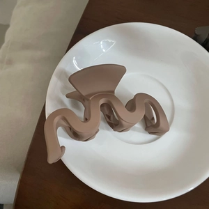 Matte wellenförmige Haarklammer in Kaffeebraun auf weißem Keramikteller für Damen