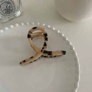 Gros plan sur une pince à cheveux en acétate écaille de tortue sur une assiette