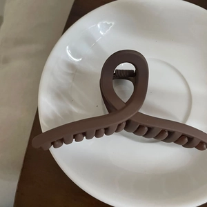 Makroansicht einer matt dunkelbraunen Haarklammer mit elegantem, gekreuztem Design