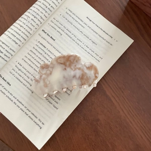 Pince à cheveux française en acétate avec motifs marbrés sur fond de livre vintage