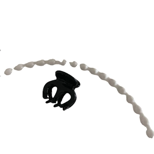 Glänzende schwarze Haarklammer aus Acetat für Damen auf minimalistischem Hintergrund