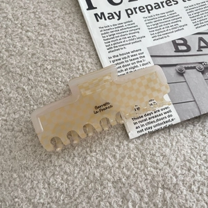 Détail d'une pince à cheveux rectangulaire à damier avec texte artistique français