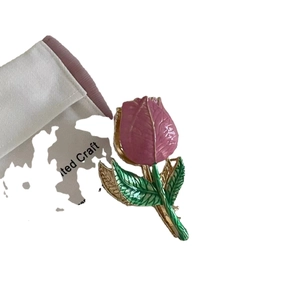 Elegant tulip claw clip in gold metal with pink and green enamel floral accents