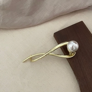 Pince à cheveux élégante en métal doré avec design entrelacé et grande perle