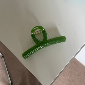 Dark green large jelly hair claw clip with golden metal spring on white background