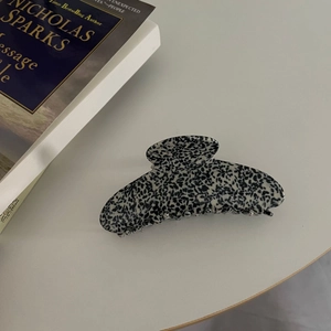Detail of a large black and white marble acetate hair claw clip for elegant hairstyles