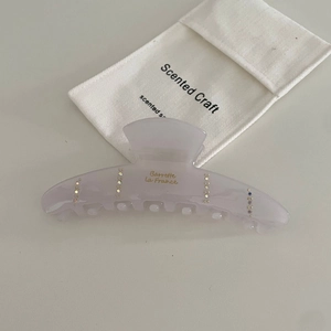 Light purple acetate hair claw with rhinestones and a branded white drawstring pouch