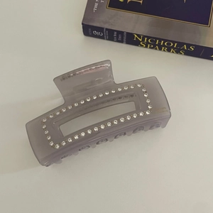Détail macro de la pince à cheveux rectangulaire en acétate avec des strass étincelants