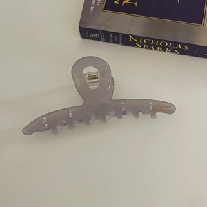 Détail de la pince à cheveux lavande translucide avec strass et lettrage doré