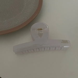 Detail of cross-shaped white acetate hair claw with gold Barrette la France text