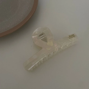 Detail view of cream acetate hair claw clip with Barrette La France gold lettering