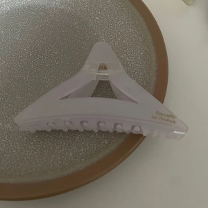 Vue détaillée d'une pince à cheveux triangulaire avec texte doré Barrette La France