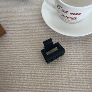 Pince à cheveux carrée noire mate de style coréen sur fond en tissu beige doux