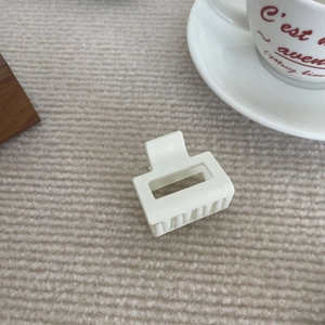 Pince à cheveux carrée évidée blanc crème sur fond de tissu tricoté beige élégant