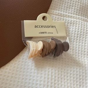 Three-piece earth-toned matte hair claw clips in beige and brown with card packaging