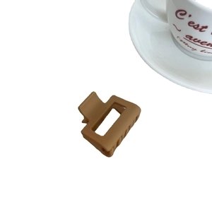 Pince à cheveux carrée marron caramel mat avec design géométrique sur fond blanc pur