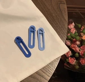 Lot de trois barrettes à cheveux bleues dégradées sur un tissu blanc épuré