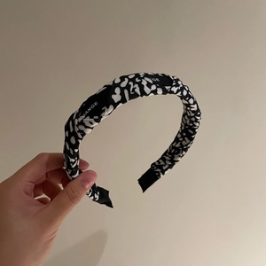 Padded headband with black and white animal print pattern and Change label detail