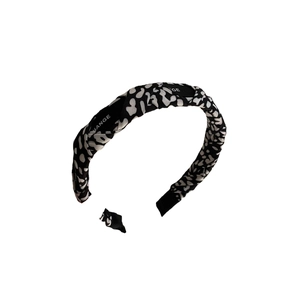 Classic black and white pattern wide headband with branded lining on a white background