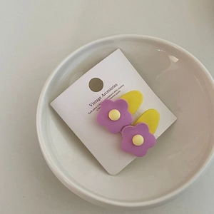 Pair of purple flower hair clips with yellow center on vintage white display card
