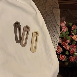 Trois barrettes à cheveux mates de couleur Morandi marron, rose poudré et blanc crème