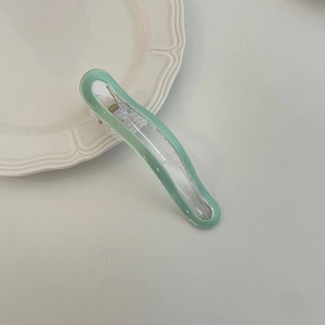 Pastel green macaron hair clip on white ceramic plate, Korean style accessory