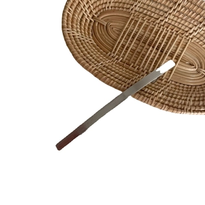 Minimalistische silberne Metall-Haarklammer mit Spiegelglanz auf einem Rattan-Tablett