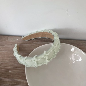Light green textured sponge headband with fringe detailing and non-slip lining