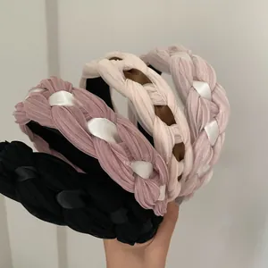 Gros plan de serre-têtes en mousseline tressée aux tons pastel et design torsadé