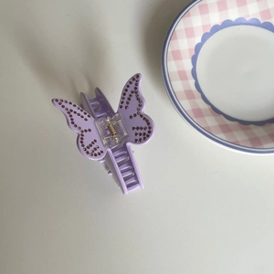 Vue détaillée d'une pince à cheveux papillon violette ornée de strass brillants