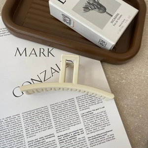 Minimalist matte cream acrylic hair claw clip for elegant long hair styling on magazine