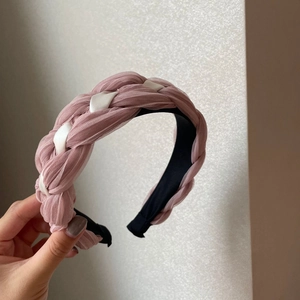 Gros plan du serre-tête tressé en mousseline rose et ruban de satin blanc