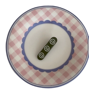 Barrette à cheveux rectangulaire verte avec smileys blancs sur une assiette décorative