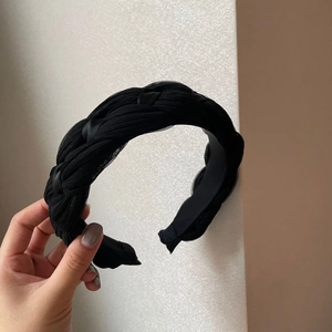 Détail d'un serre-tête tressé en mousseline noire avec des couches de mesh texture