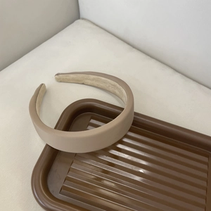 Close-up of padded fabric headband in beige with non-slip velvet lining detail
