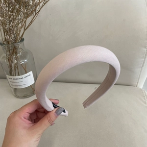 Close-up of padded light pink sponge headband showing soft fabric texture and curved design
