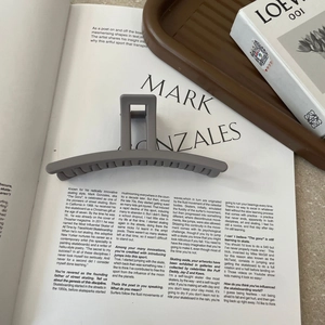 Matte dark grey large hair claw clip on a minimalist magazine for thick hair styling