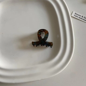 Detailaufnahme einer Mini-Haarklammer mit Schildpattmuster in Blau- und Brauntönen