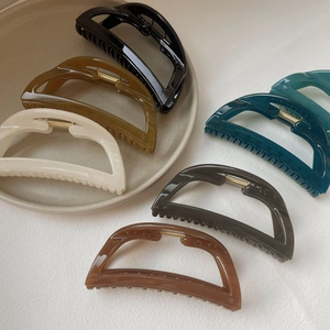 Morandi large shark hair claw clips in 6 colors displayed on a beige ceramic plate