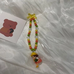 Close-up of colorful macaron beads and a cute cartoon girl charm with a straw hat