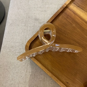 Detail of caramel and clear acrylic cross hair claw clip with strong metal spring